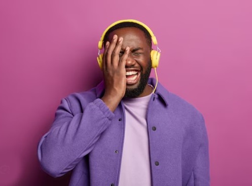 An African man listening to music with sad emotional expression. 
